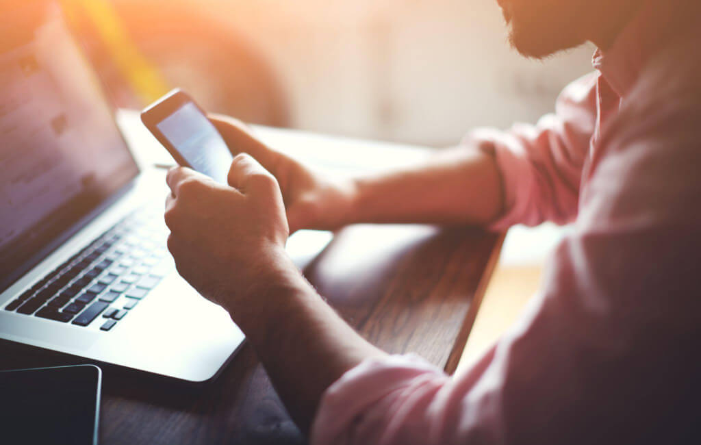 Person using their phone and laptop |Why is mobile advertising important?